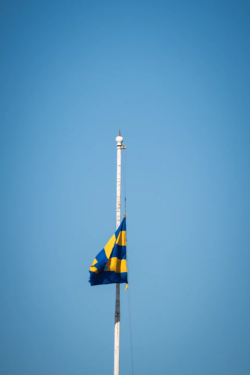 Bandera azul y amarilla de Belgrano en el tramo superior del mástil